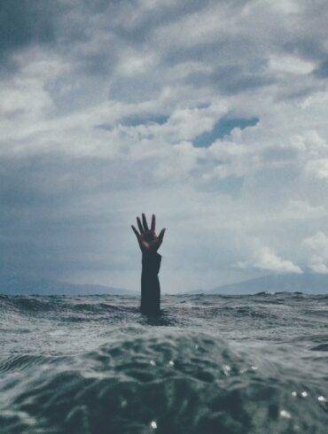 photo of person reach out above the water