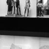 grayscale photo of woman in black dress standing in front of mirror
