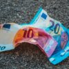 two 20 and 10 banknotes on gravels