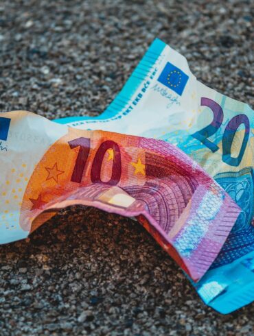 two 20 and 10 banknotes on gravels