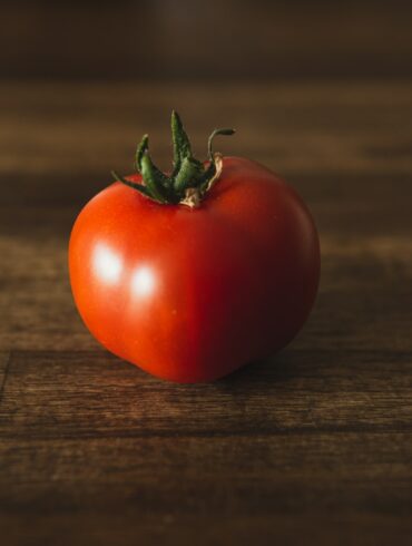 red tomato on brown wooden table