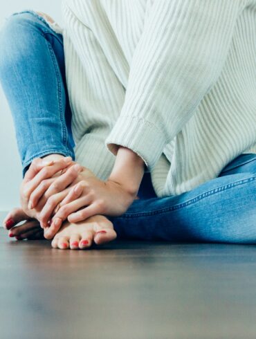 person wearing distressed blue denim jeans inside room