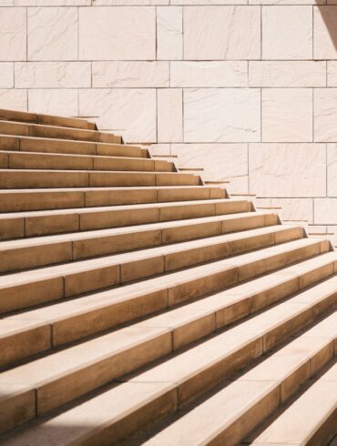 toddler's standing in front of beige concrete stair