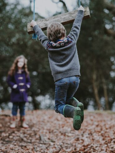 boy holding on swing bench