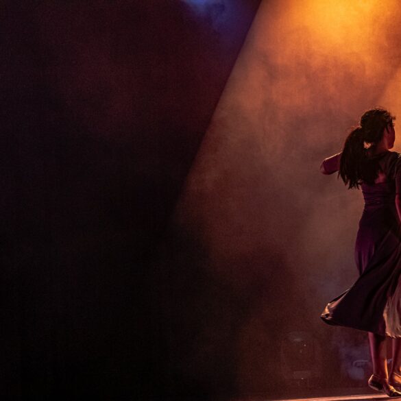man in black jacket singing on stage