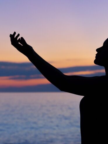 silhouette of woman raising her right hand