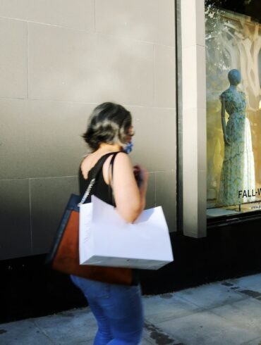 woman in white shirt and blue denim jeans standing in front of mirror