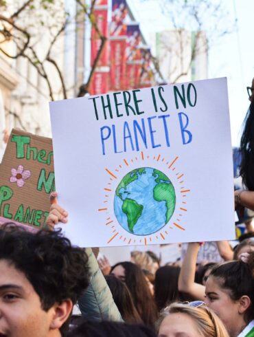 person holding there is no planet b poster