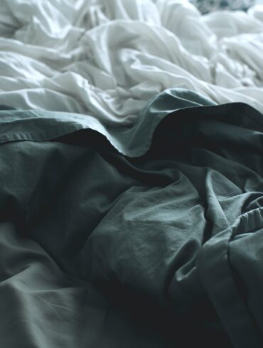 gray apparel beside white sheet