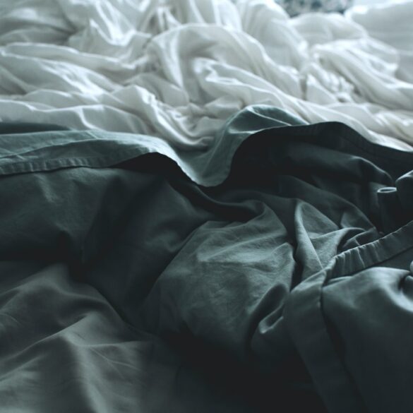 gray apparel beside white sheet
