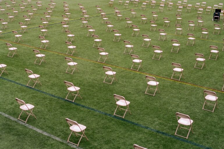 white folding chairs on green grass field