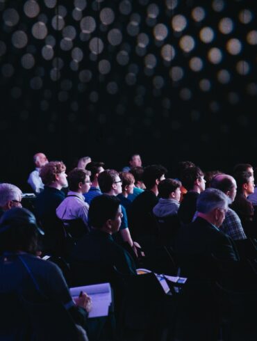 crowd of people sitting on chairs inside room