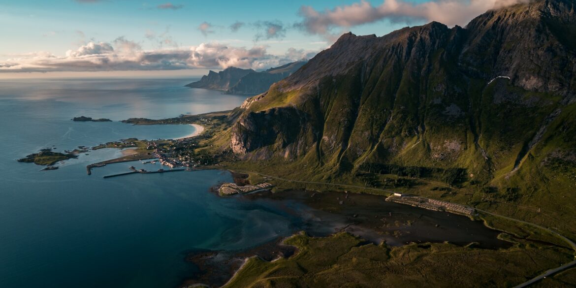 buildings near body of water and rock formation