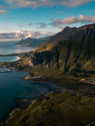 buildings near body of water and rock formation