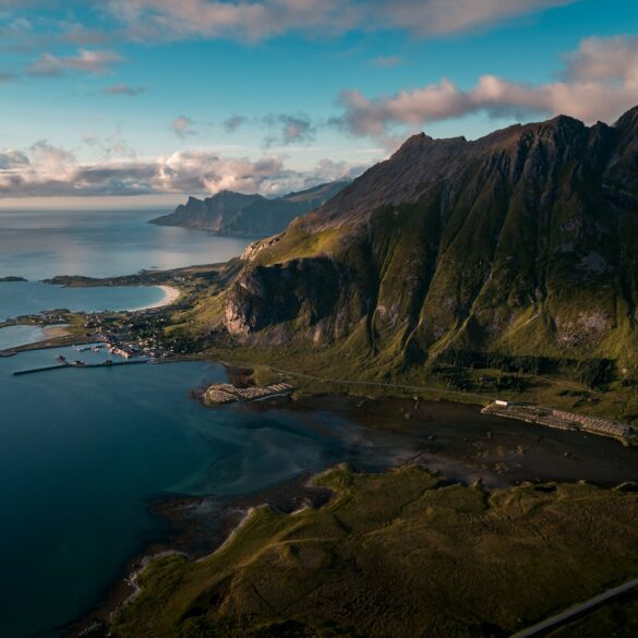 buildings near body of water and rock formation
