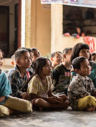 group of childrens sitting on ground