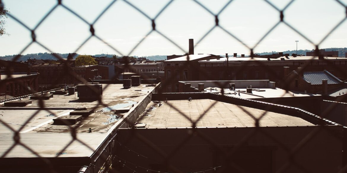 a view of a building through a chain link fence