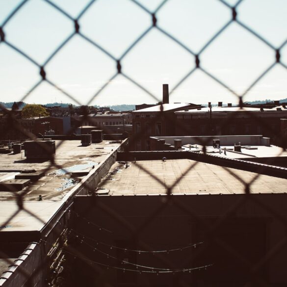 a view of a building through a chain link fence