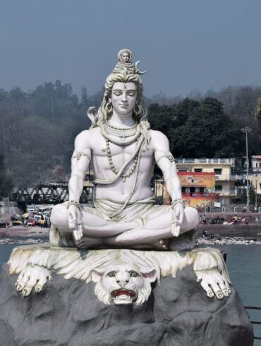 a statue of a person sitting on top of a rock