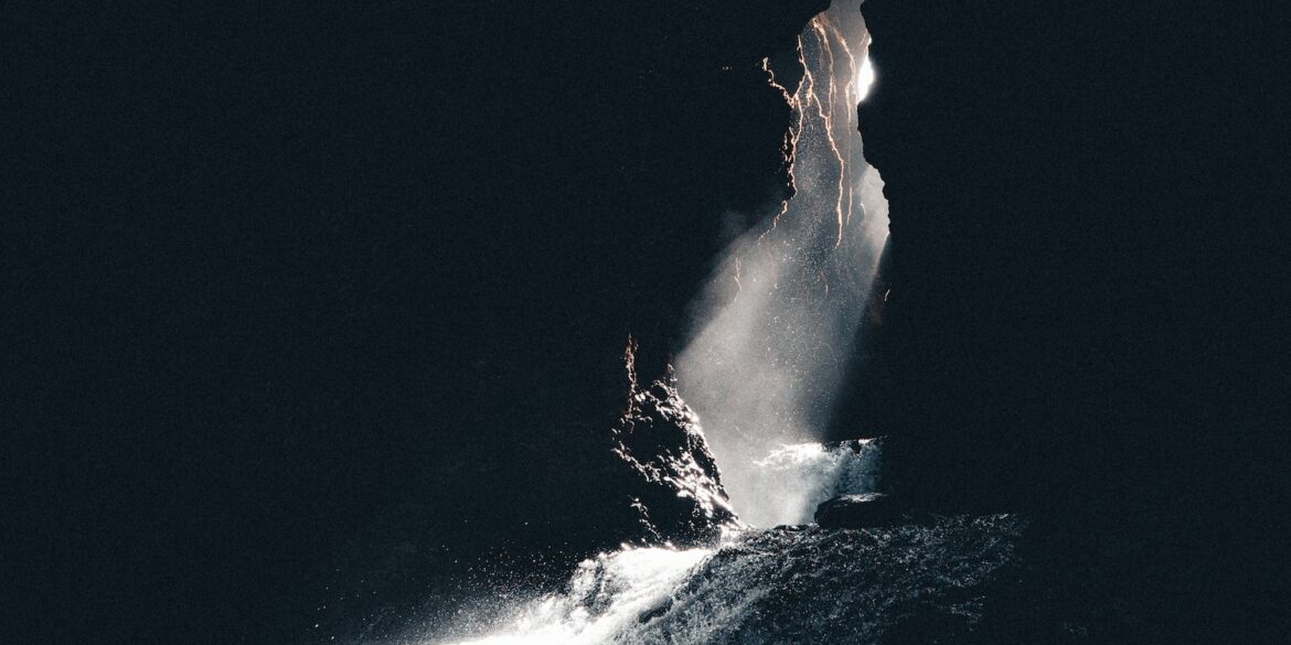 a large rock sticking out of a body of water