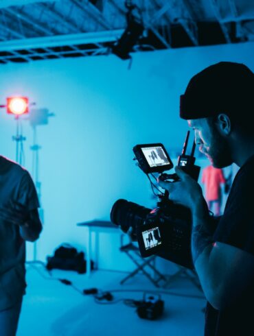man in white dress shirt holding black camera