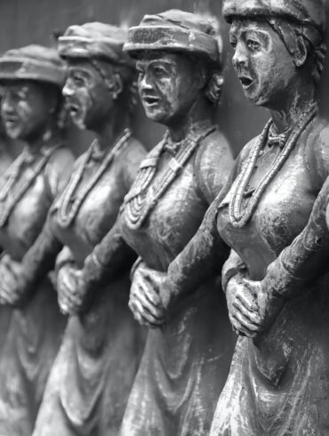 grayscale photo of man and woman statue