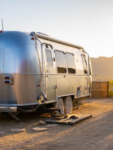 white and blue van on brown dirt road during daytime