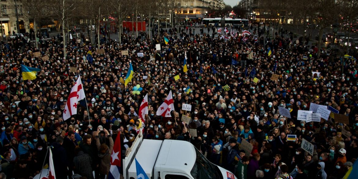 a large crowd of people standing around a white van