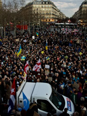 a large crowd of people standing around a white van