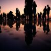 silhouette of people standing on mirror during golden hour