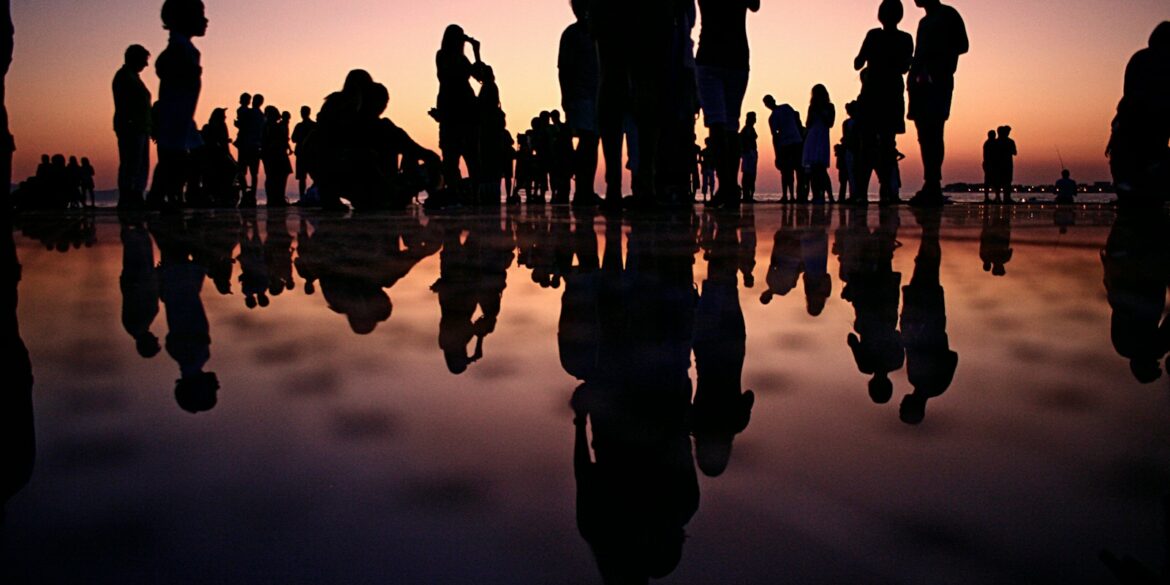 silhouette of people standing on mirror during golden hour