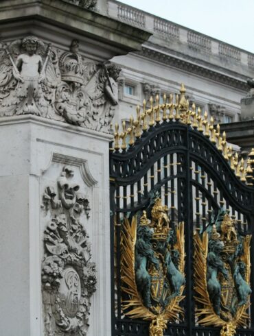 a black and gold gate with statues on it