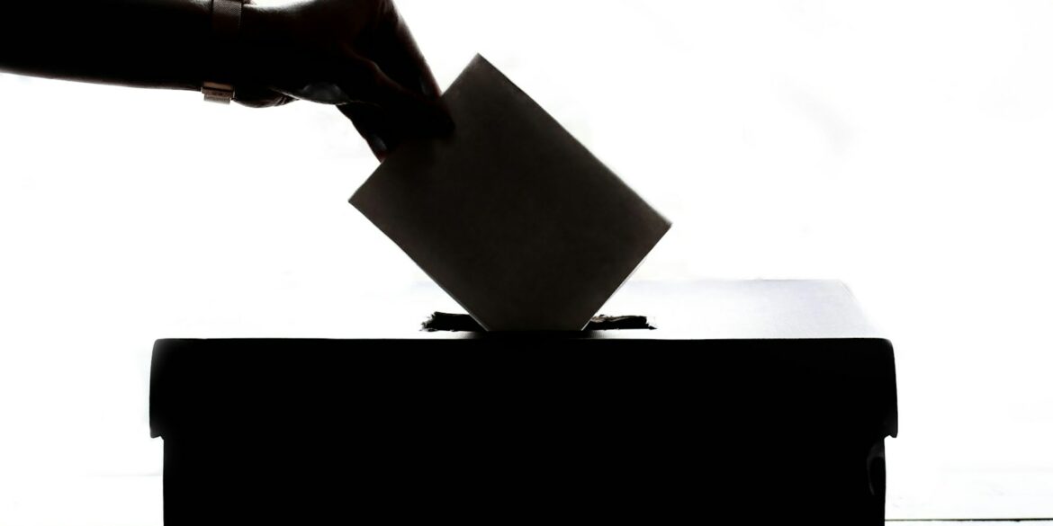 a person is casting a vote into a box