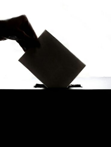 a person is casting a vote into a box