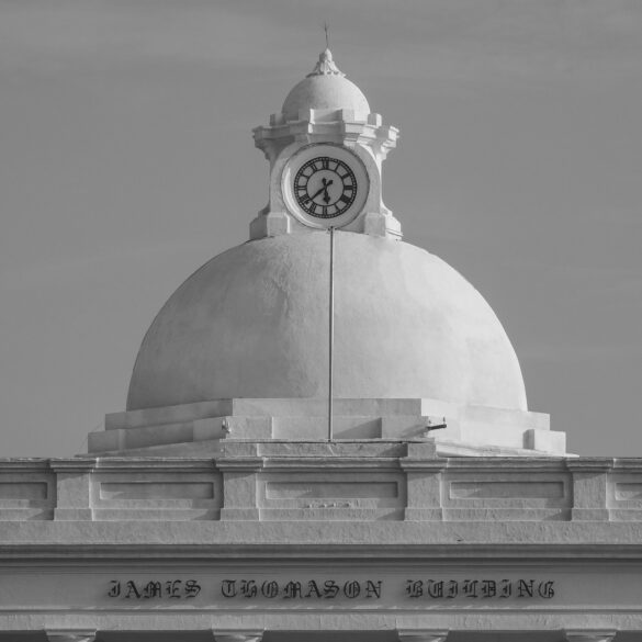 a black and white photo of a clock on top of a building