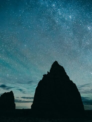silhouette of rocky mountain under starry sky