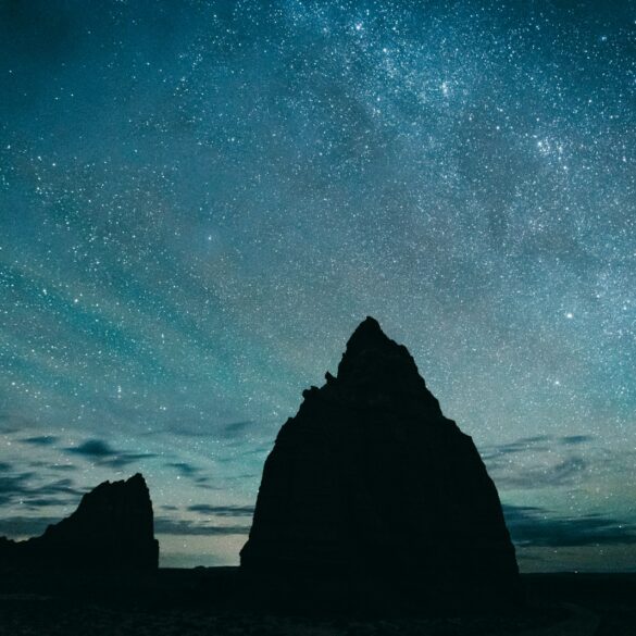 silhouette of rocky mountain under starry sky