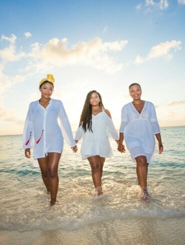 three women holding hands in seashore