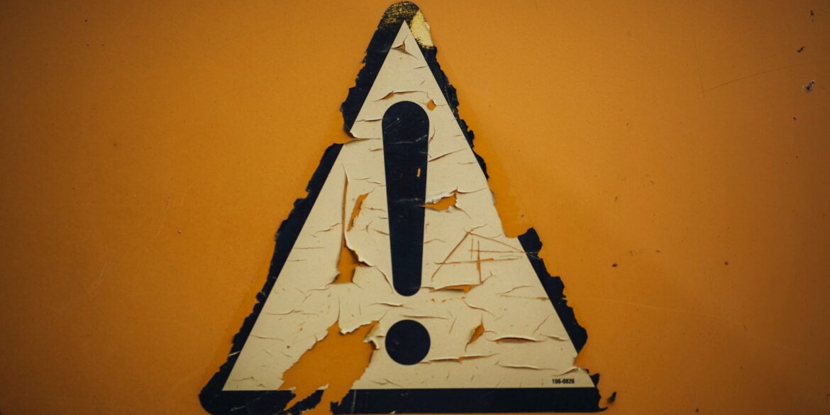 a triangle shaped sign on a yellow wall