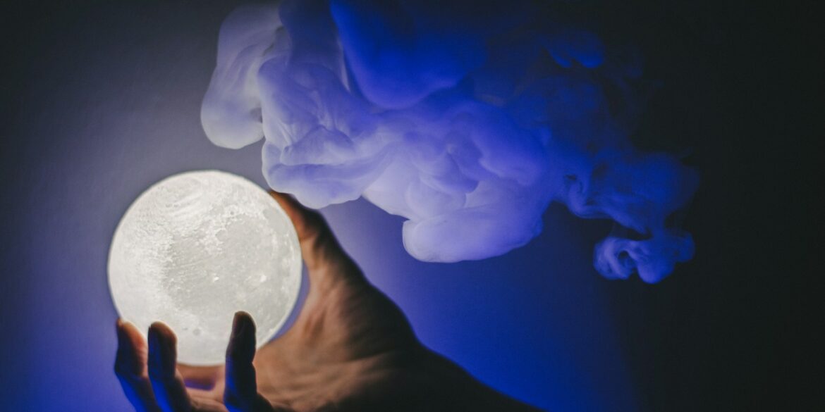 a person holding a white moon in their hand