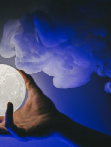 a person holding a white moon in their hand