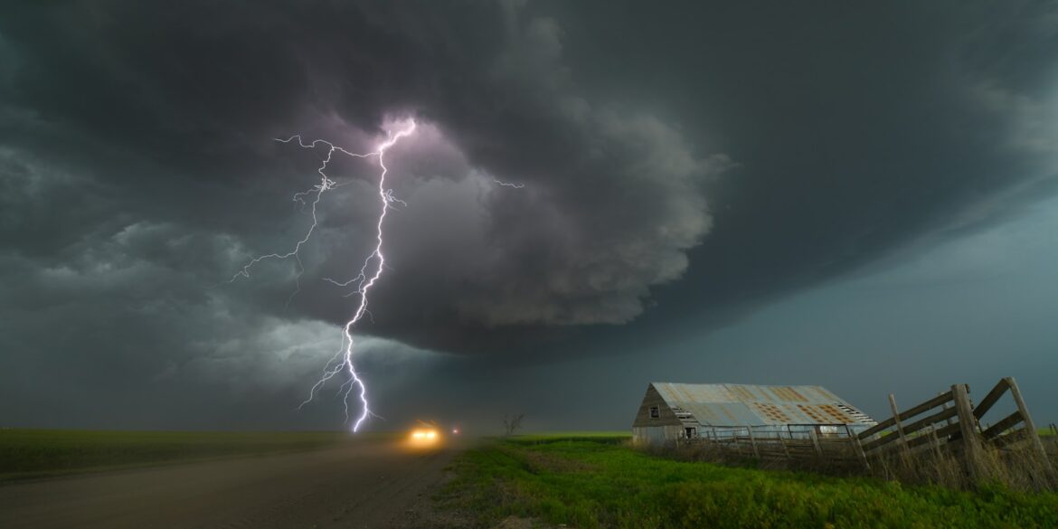 a lightning bolt hitting over a farm in the country