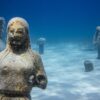 a statue of a man and a woman in the water