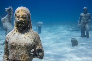a statue of a man and a woman in the water