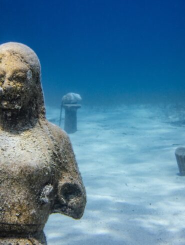 a statue of a man and a woman in the water