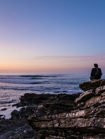 person sitting on cliff