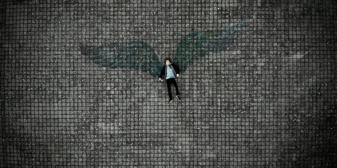 person in black pants walking on gray concrete pavement