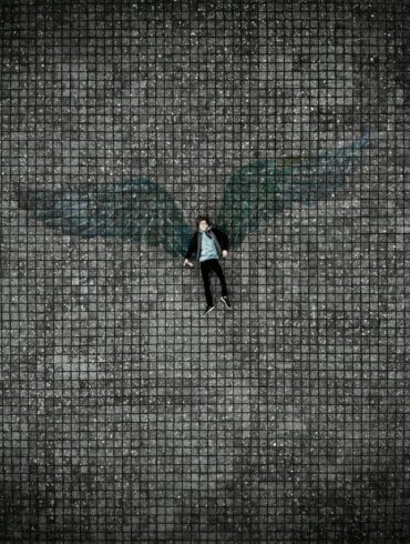 person in black pants walking on gray concrete pavement