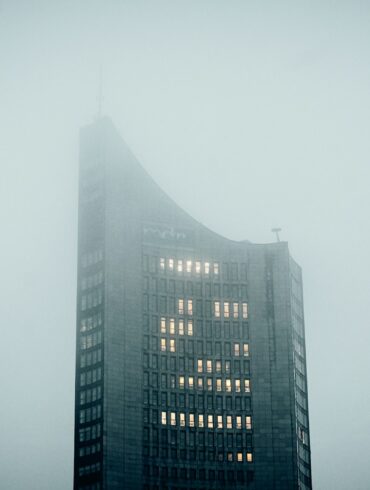 a very tall building in the middle of a foggy day
