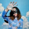 woman in blue and white floral long sleeve shirt wearing black sunglasses
